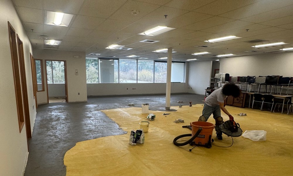 King County employee removing old carpet from an office area at the new RASKC facility