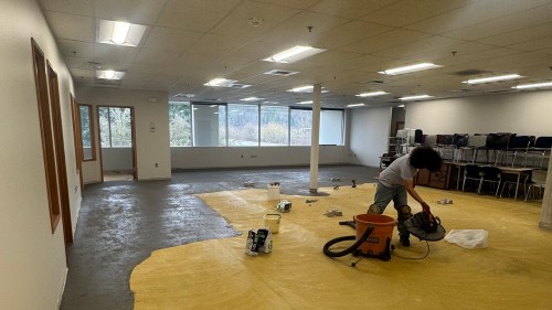 King County employee removing old carpet from an office area at the new RASKC facility
